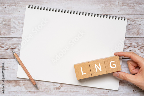 LNGのイメージ｜「LNG」と書かれた積み木、ペン、ノート、人の手
