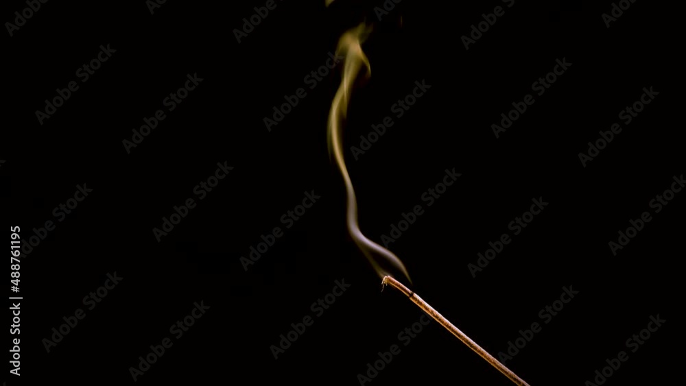 An incense stick burns and smokes. An incense stick burns and smokes.