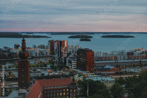   The view of old Swedish town Vasteras from above, with old brick buildings and modern appartment houses and lake in the background, shot in the evening.