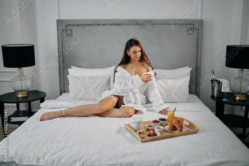 a woman in a bathrobe with breakfast in bed