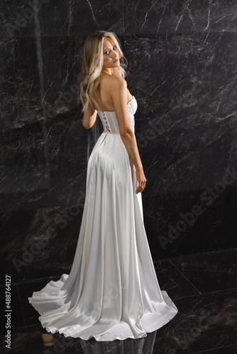 elegant stylish female in a delicate wedding dress on a black background 