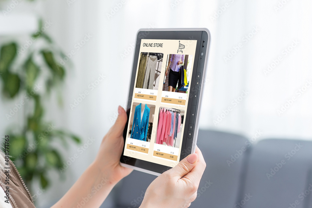 Woman looking for new clothes in online store on digital tablet Woman looking for new clothes in online store on digital tablet