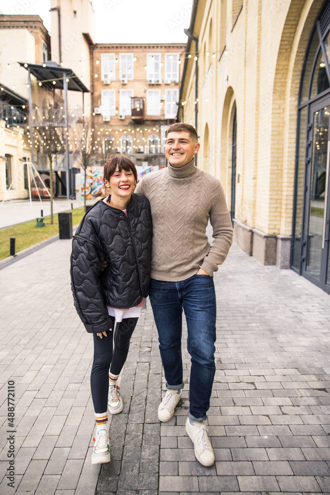 young beautiful couple walking and having fun on the city street