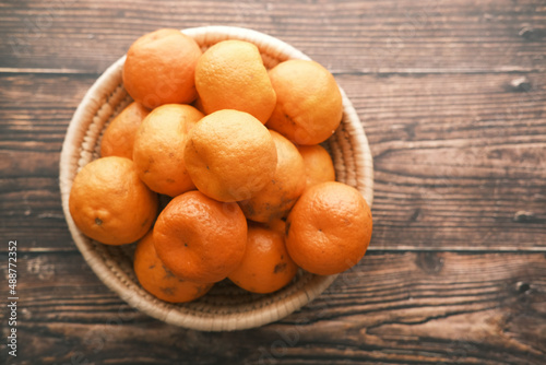 many orange fruits in a bowl on table 