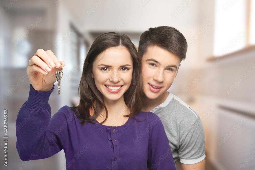Happy millennial couple showing keys, smiling, hugging. Husband and wife, new homeowners, real estate property purchase, renting apartment. Happy millennial couple showing keys, smiling, hugging. Husband and wife, new homeowners, real estate property purchase, renting apartment.