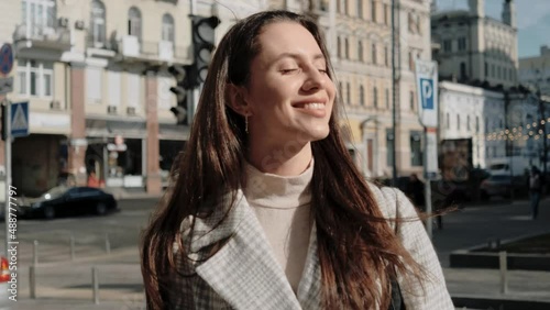 Young brunette woman enjoying a sunny spring day on the street