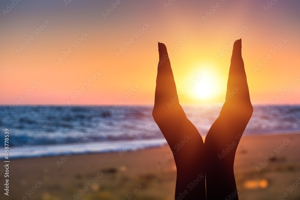 Summer sun concept with silhouette of young woman's hands relaxing, happy meditating