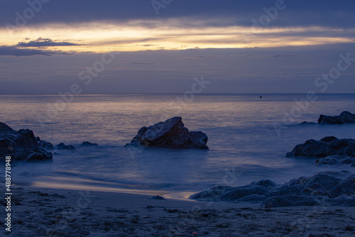 Blue sunset on the beach with rocks in Malaga district, Spain