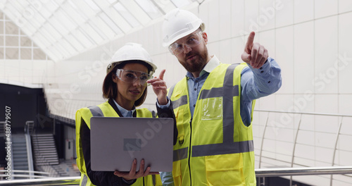 Εκτύπωση καμβά Male civil engineer and female architect standing inside new business office center discussing design details