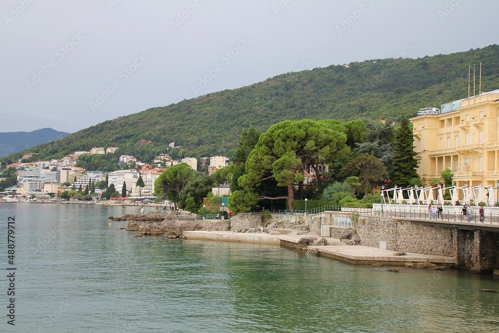 view of the sea coast, seaside and buildings close to the beach, beautiful Mediterranean coast in Opatija, Croatia, old Austro-Hungarian holiday town, rocky shores of the Mediterranean sea, historic 