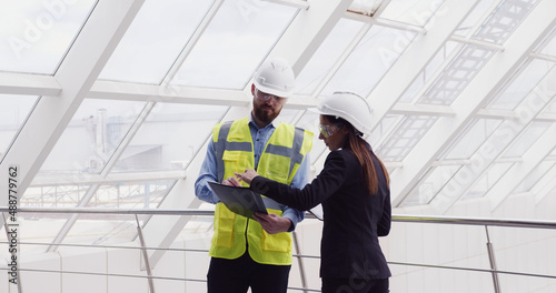 Female human resourses manager talking to company chief male engineer, asking questions about job satisfaction. Businesswoman investor communicating with real estate developer at construction site.
