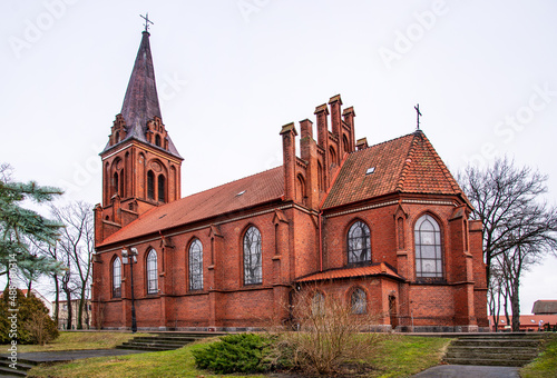 General view and close-up of architectural details of the Catholic church of Saint Bruno built in the neo-Gothic style in the city of Bartoszyce in warmi in Poland, built in the years 1882-83.