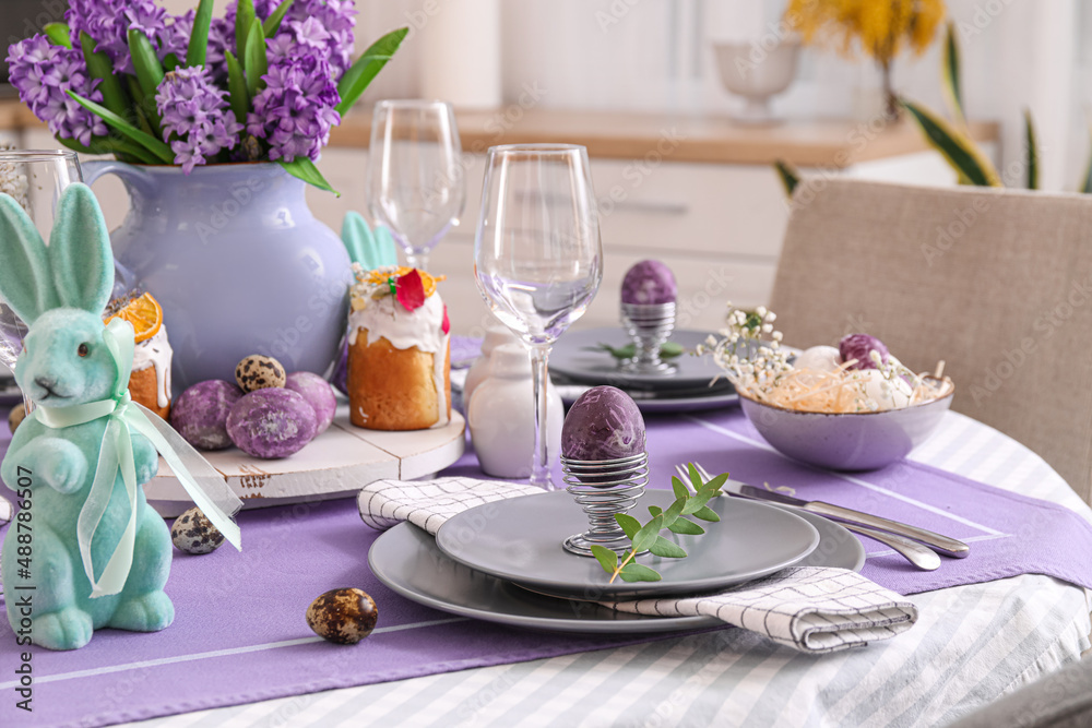 Holder with painted Easter egg and eucalyptus branch on served table Holder with painted Easter egg and eucalyptus branch on served table