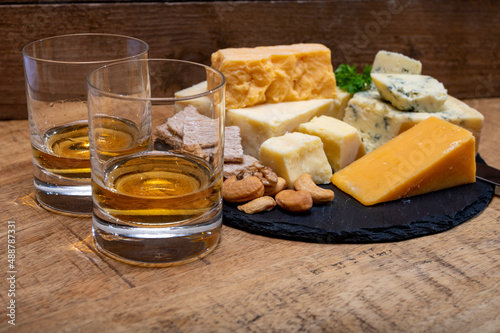 British drinks and food, glasses of Scotch whisky and cheeses collection, blue Stilton, Scottish coloured and English matured cheddar cheeses