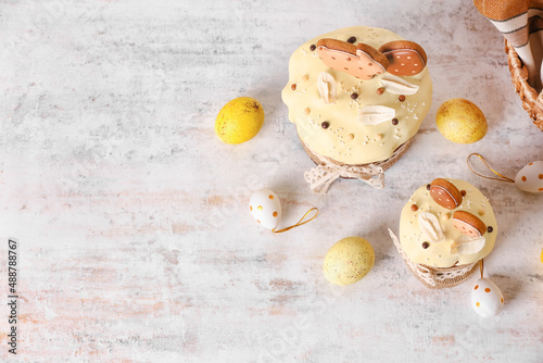 Delicious Easter cakes decorated with cookies and eggs on light background