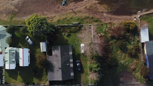 small peninsula with houses surrounded by water drone flying up