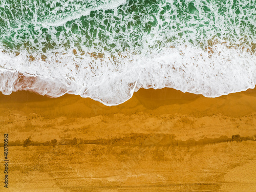 Top view of waves crushing on sandy beach in Albufeira, Algarve, Portugal © malajscy