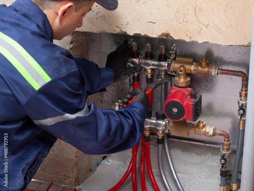 Technician installing underfloor heating collector