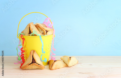 Purim celebration concept (jewish carnival holiday). Hamantaschen cookies over wooden table