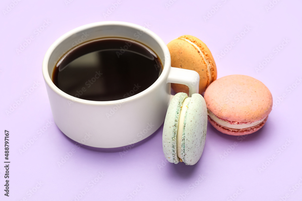 Cup of coffee and sweet macaroons on lilac background Cup of coffee and sweet macaroons on lilac background