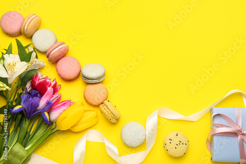 Composition with flowers for International Women's Day celebration, gift and macaroons on yellow background