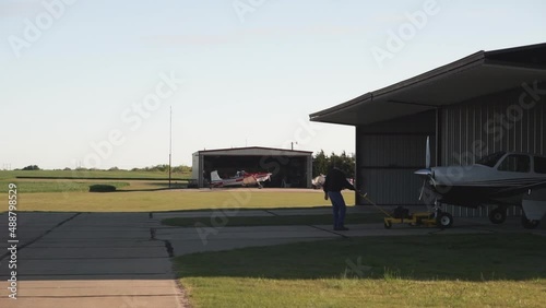 Man Pulling Small Aircraft out of Hangar