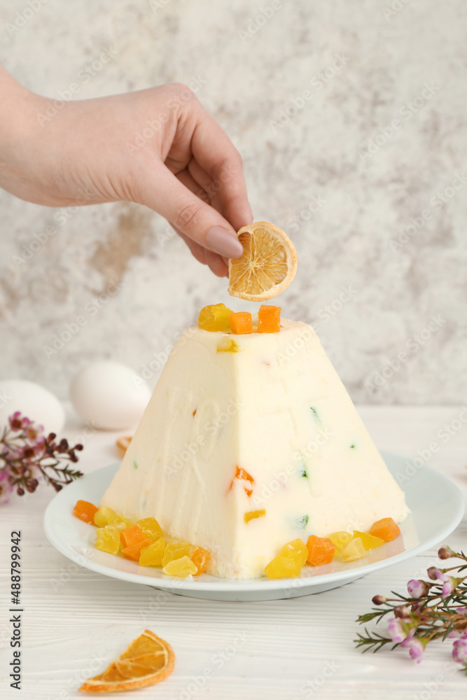 Woman decorating curd Easter cake on table, closeup Woman decorating curd Easter cake on table, closeup