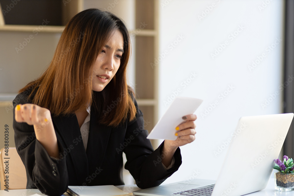 Serious business woman looking at her financial bill. Serious business woman looking at her financial bill.