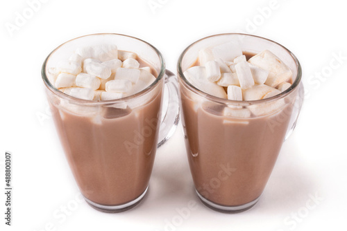 Two mugs with hot cocoa drink and marshmallow on a white isolated background.