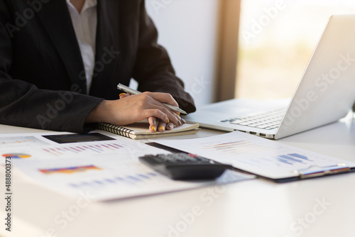 Female secretary working at desk in office with laptop. The financial advisor at the office desk is ready to give advice.