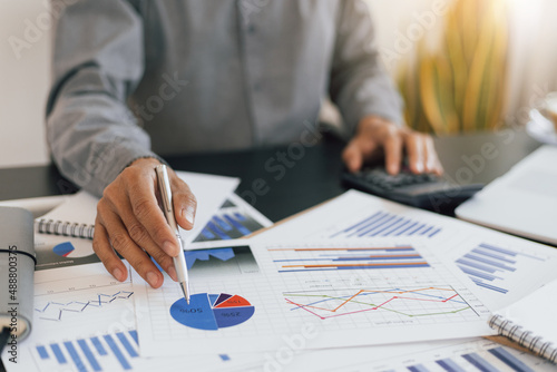 Businessman pointing to business white paper and analyzing planning.