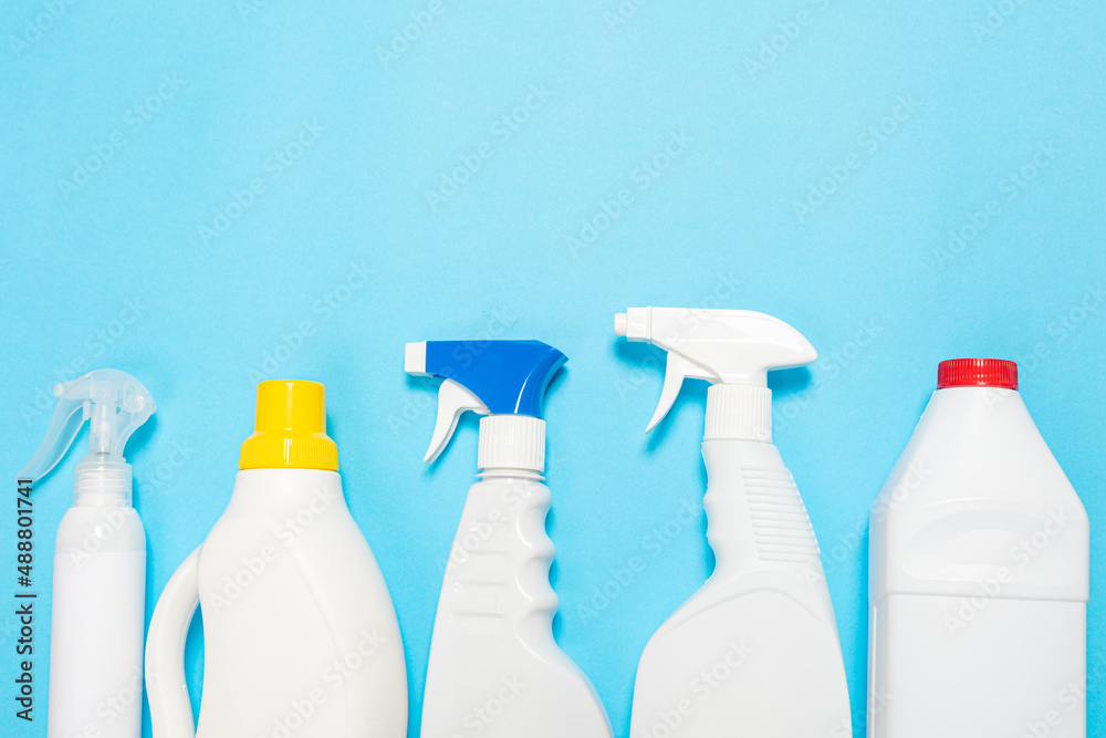 House cleaning supplies on blue background. Row of plastic bottles with cleaning liquid and sponges. Cleaning business, production, shopping and delivery. House cleaning supplies on blue background. Row of plastic bottles with cleaning liquid and sponges. Cleaning business, production, shopping and delivery.