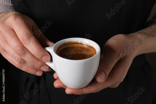 Woman holding cup of fresh aromatic espresso, closeup