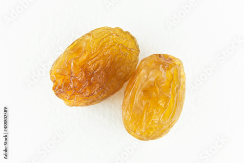 Two brown raisins on a white isolated background.