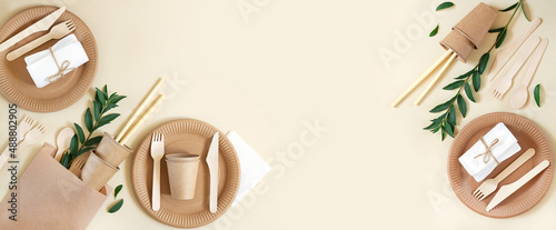 Banner with eco craft paper tableware and wooden cutlery background
