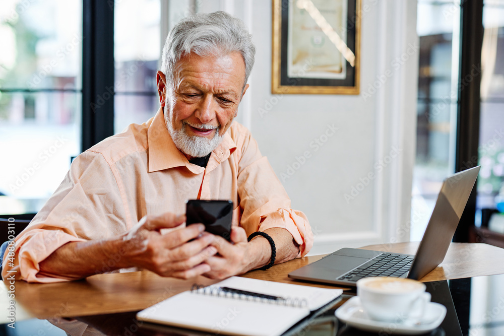 A senior student sitting in cafe and using phone in the moment of studying. A senior student sitting in cafe and using phone in the moment of studying.