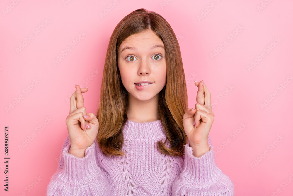 Photo of unsure uncertain girl dressed knitted pullover fingers crossed biting lip isolated pink color background Photo of unsure uncertain girl dressed knitted pullover fingers crossed biting lip isolated pink color background