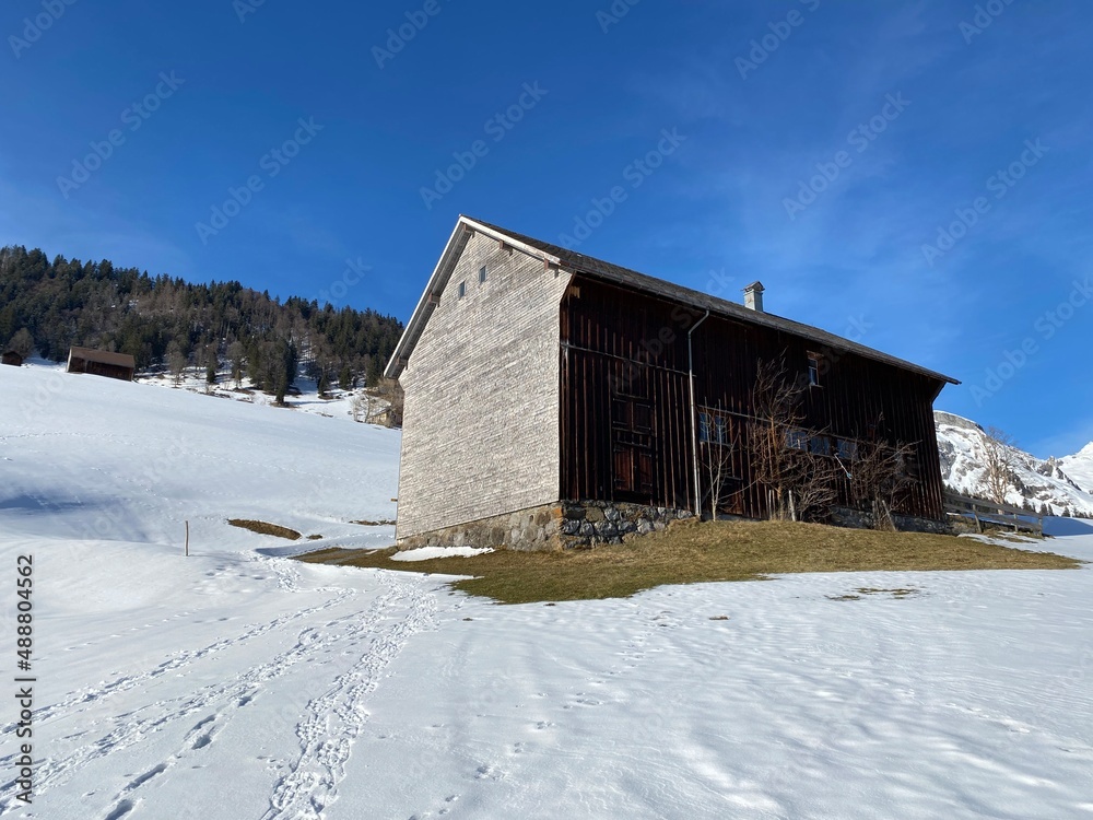 Indigenous alpine huts and wooden cattle stables on Swiss pastures covered with fresh white snow cover, Alt St. Johann - Obertoggenburg, Switzerland (Schweiz) Indigenous alpine huts and wooden cattle stables on Swiss pastures covered with fresh white snow cover, Alt St. Johann - Obertoggenburg, Switzerland (Schweiz)