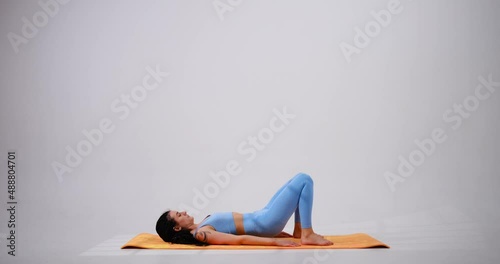 Young woman doing glute bridge exercise over white background photo