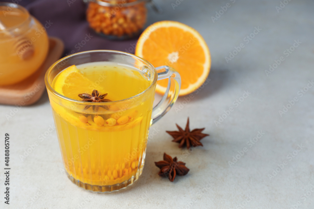 Glass cup of immunity boosting drink and ingredients on grey table, space for text Glass cup of immunity boosting drink and ingredients on grey table, space for text