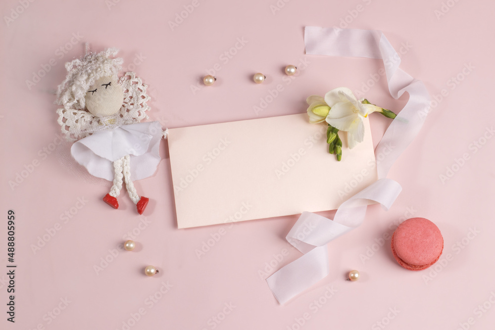 Invitation or greeting card mockup with envelope, freesia flower and macaron cake on soft pink background. Invitation or greeting card mockup with envelope, freesia flower and macaron cake on soft pink background.