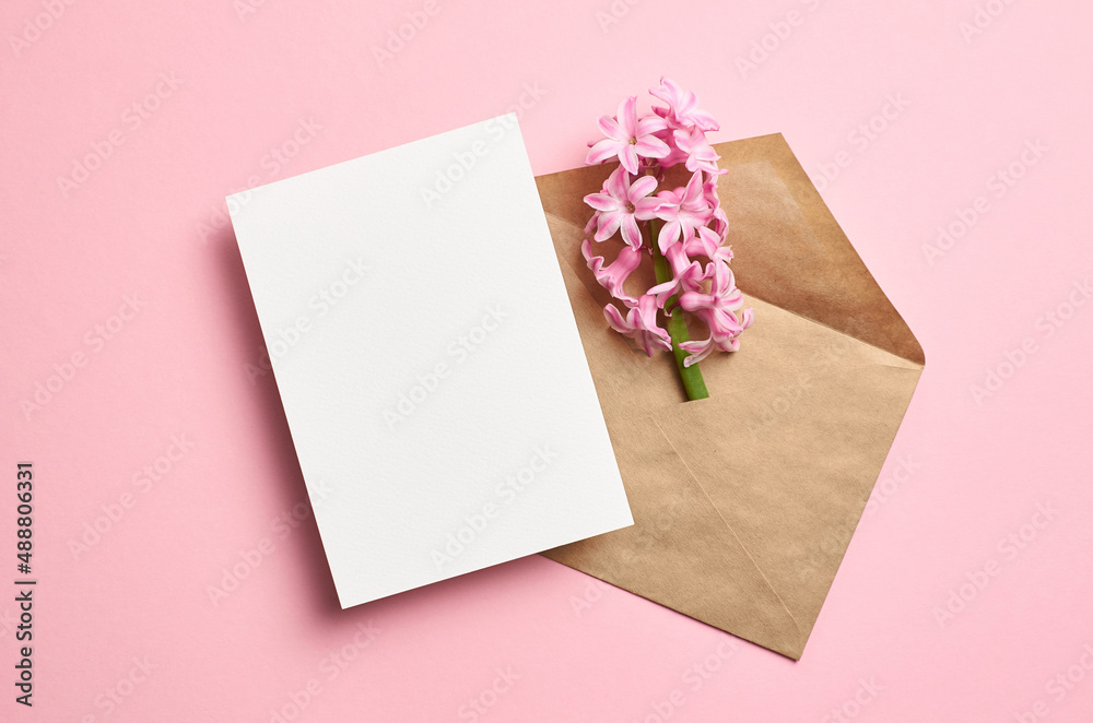 Greeting card mockup with envelope and hyacinth flowers on pink background