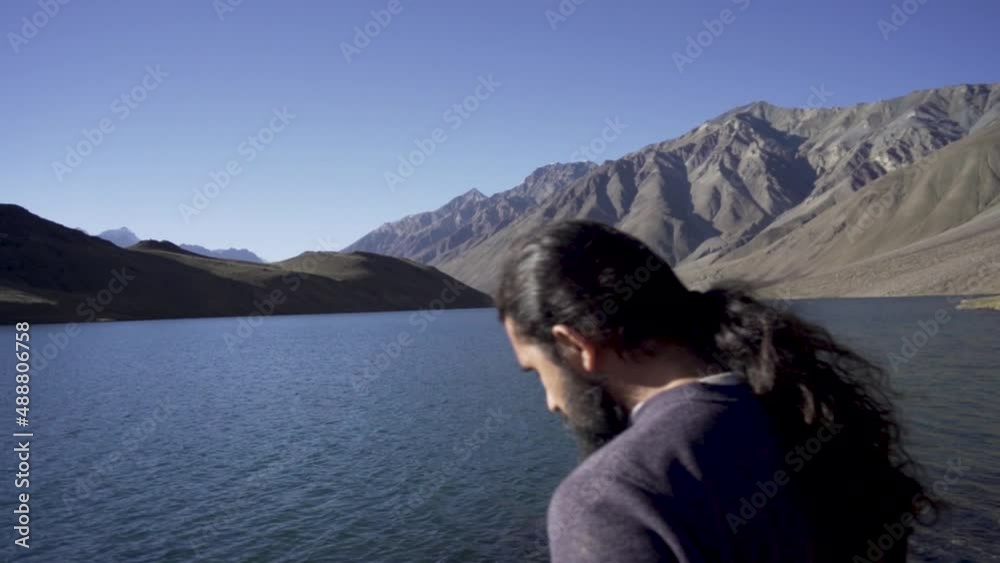 Young man enjoying the nature and feeling the beauty of chandratal lake(moon lake), Himachal Pradesh. A man alone into himalayas. Travel Lifestyle. Young man enjoying the nature and feeling the beauty of chandratal lake(moon lake), Himachal Pradesh. A man alone into himalayas. Travel Lifestyle.