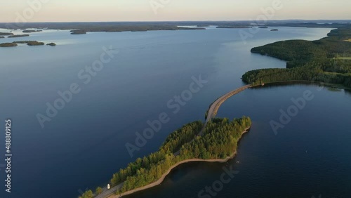Aerial view of of islands on a blue lake Paijanne. Blue lake, islands and green forest from above on a sunny summer evening. Lake landscape in Finland