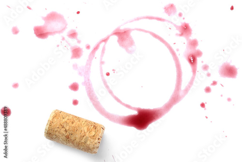 Red wine rings, drops and cork on white background, top view