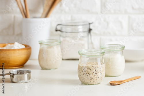 Glass jars with active sourdough starter.