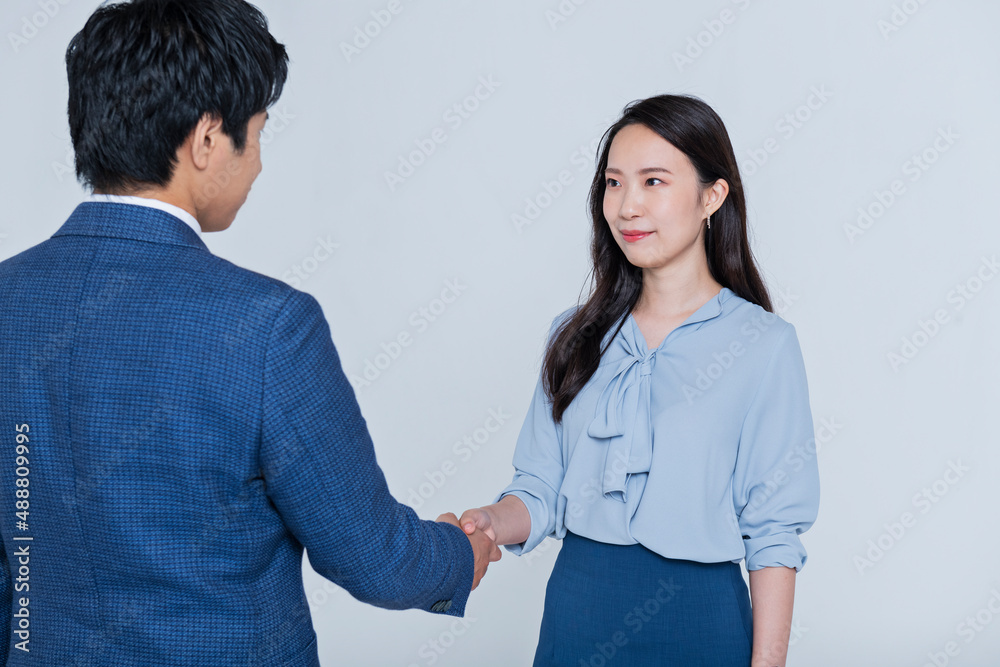 ビジネスシーンで握手をする男女
