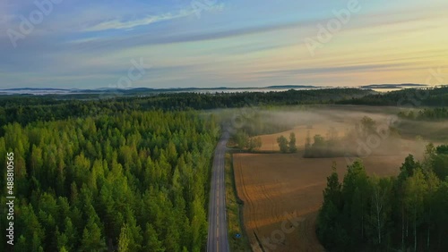 Aerial footage video of foggy summer morning. Flying over forest and lake. 