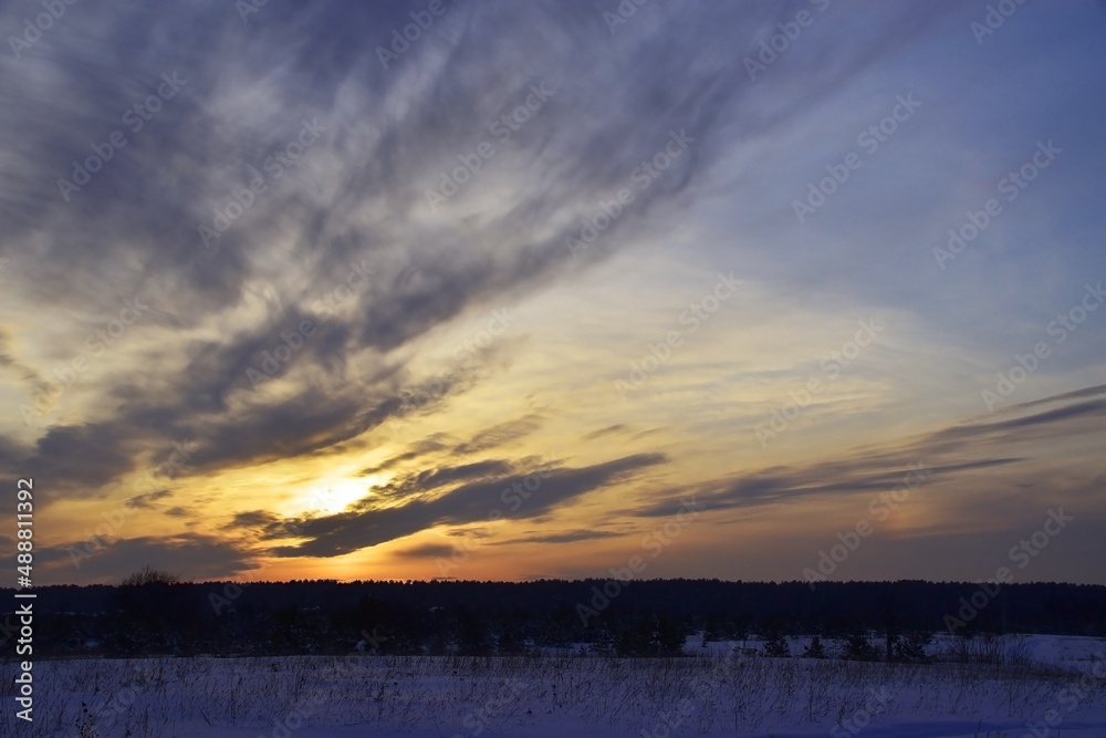 Cloudy winter sunset over snowy ground. Cloudy winter sunset over snowy ground.
