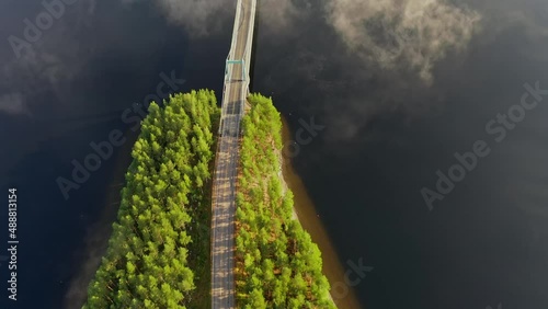 Aerial view of the road between the islands of blue lake Paijanne. Blue lake, islands and green forest from above on a sunny summer evening. Lake landscape in Finland